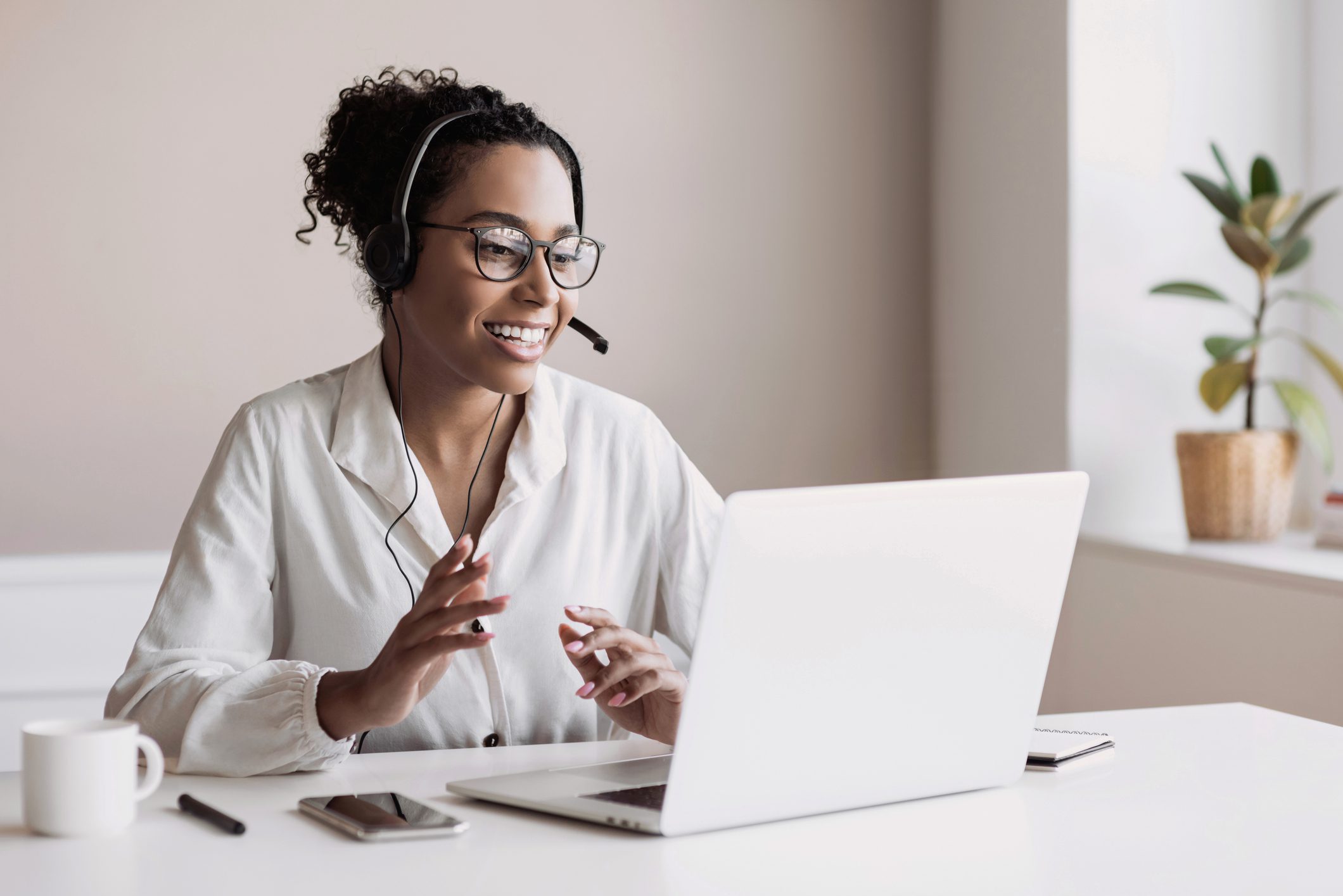 Woman smiling and gesturing while video calling on laptop.